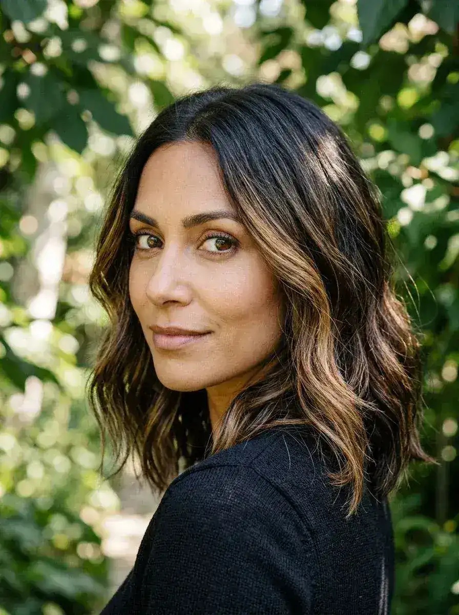 Dame med mørk lob, balayage-highlights og løse bølger utendørs